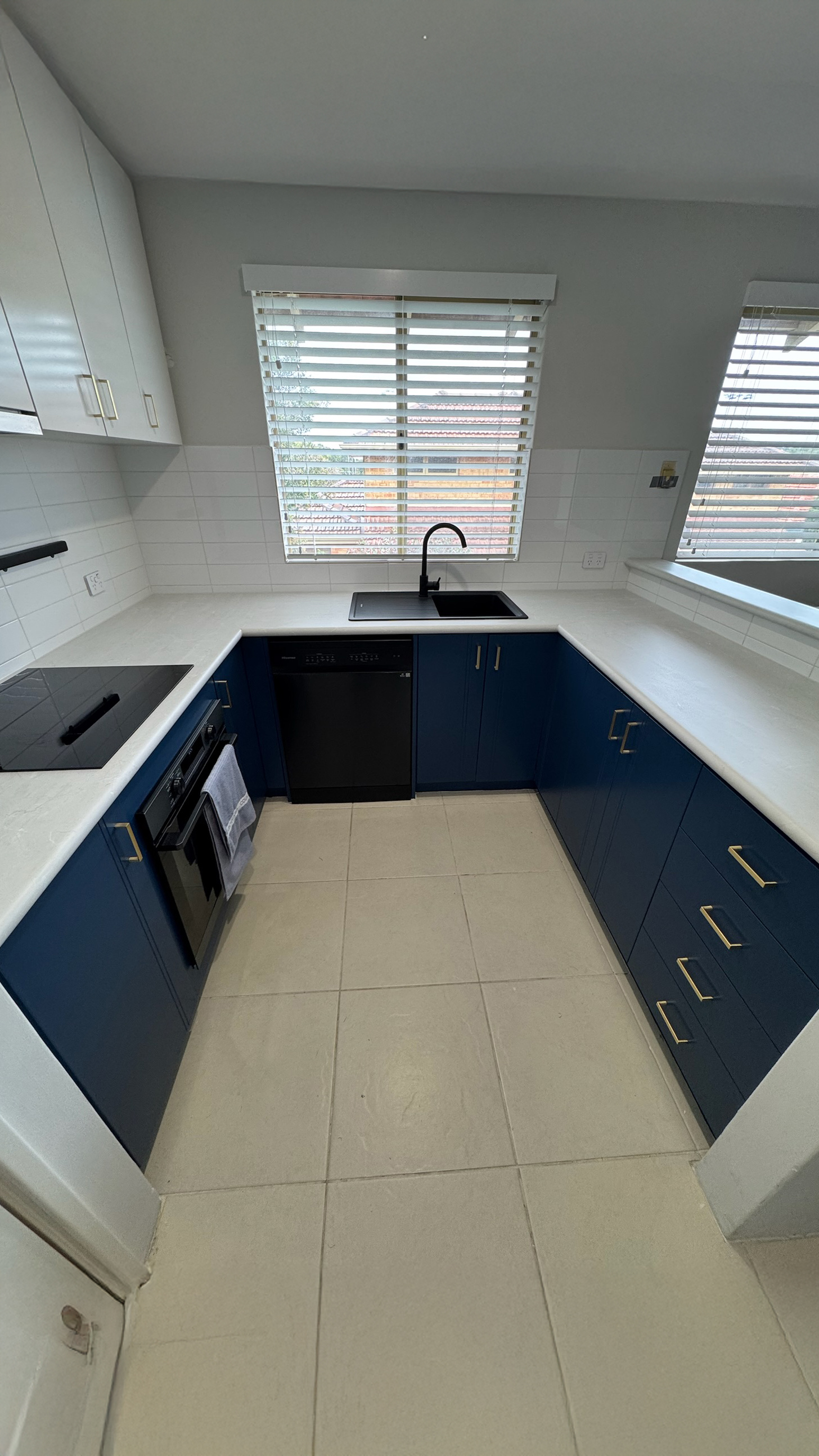 Benchtop-only wrap over a navy kitchen after