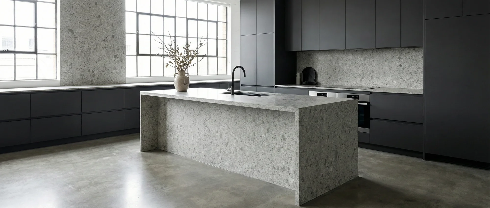 Stone-wrapped kitchen island with charcoal cabinetry
